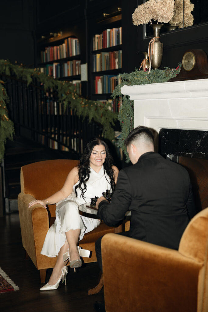 Couple playing chess in the library at Hotel 1928, candid and relaxed.