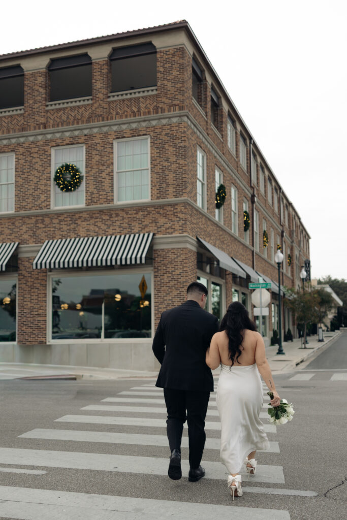 Couple walking hand-in-hand down a quiet Waco street, natural and candid.