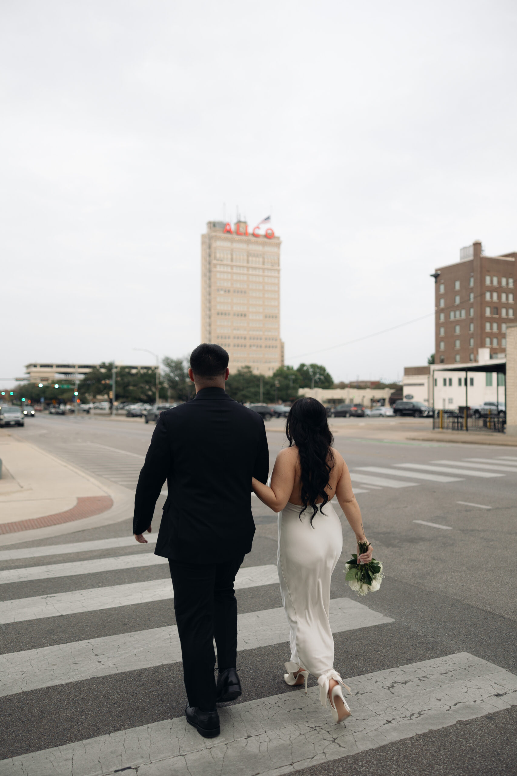 Couple walking hand-in-hand through Waco, Texas during their courthouse elopement, captured in a natural, documentary style.