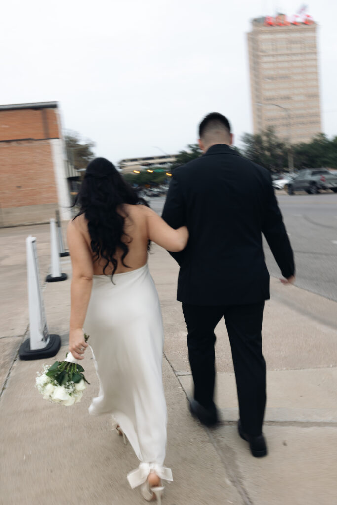 Bride and groom walking across Downtown Waco during their elopement.