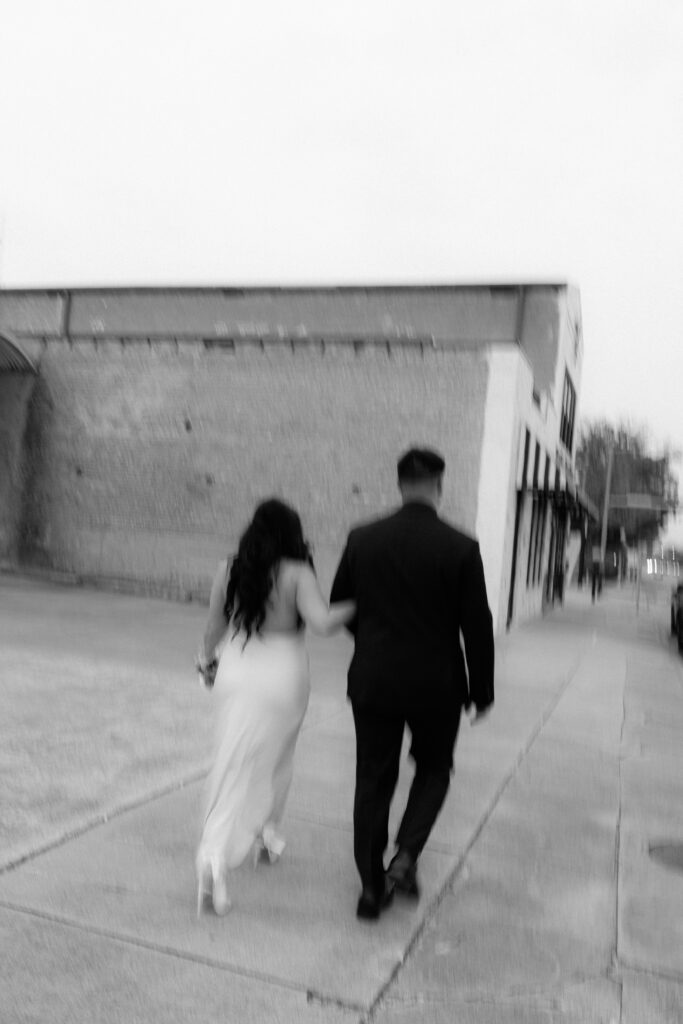 Couple laughing while walking along the Waco sidewalks, documentary style.