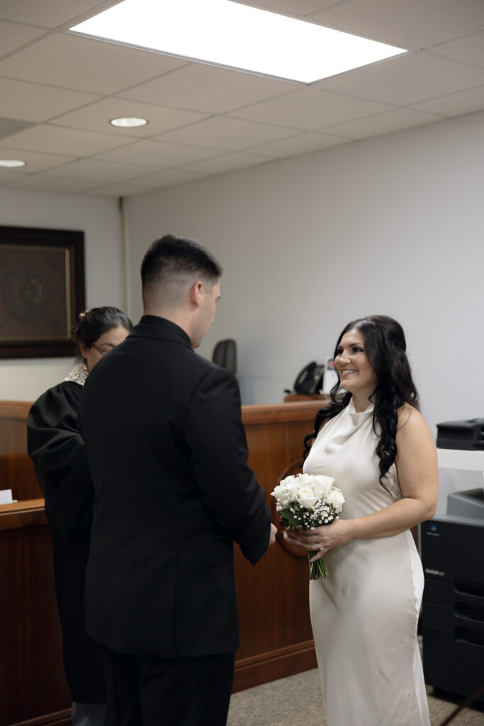 Couple smiling during their civil ceremony at Waco courthouse.
