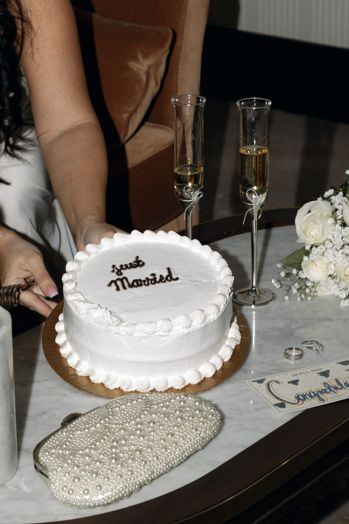 Bride and groom cutting their wedding cake in the hotel room at Hotel 1928.