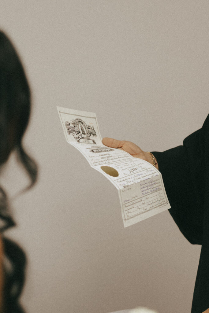 Couple signing marriage certificate after having their elopement at the courthouse in Waco.