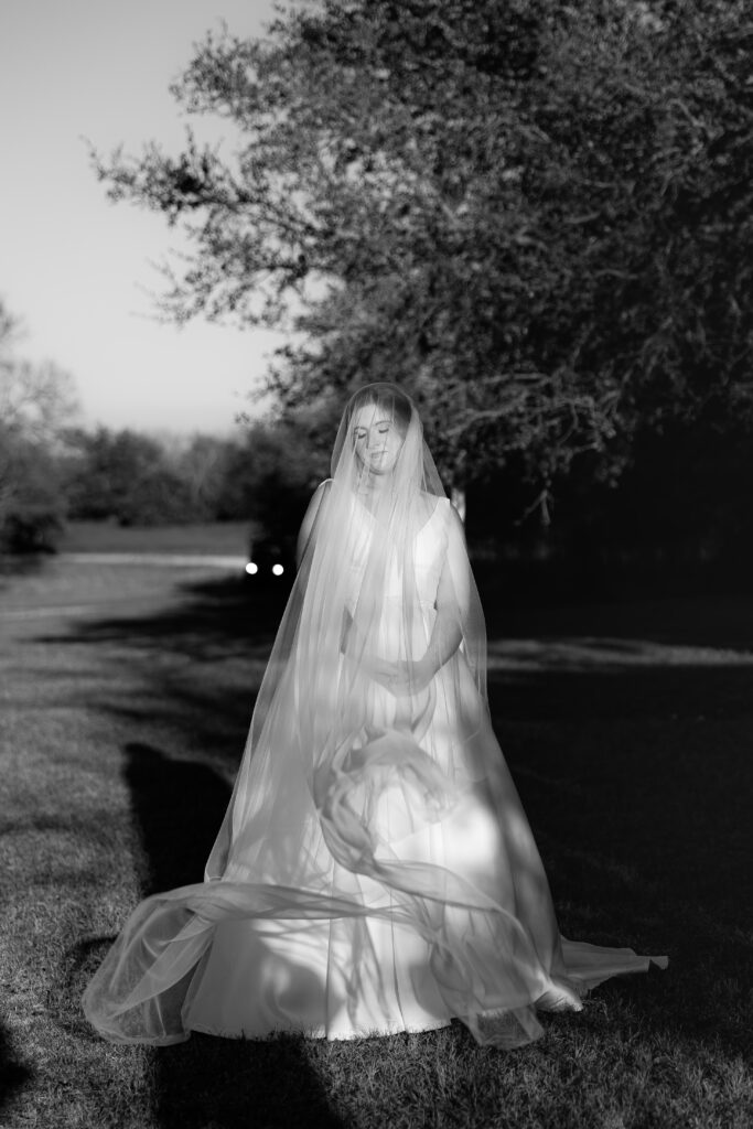 Bride standing in dramatic light with veil overhead during a Christmas wedding in Waco, Texas